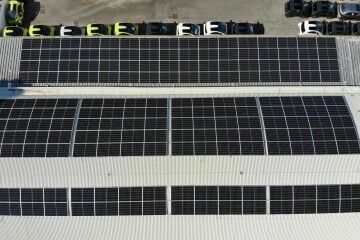 Pannelli solari installati sul tetto di un edificio, visti dall'alto.