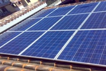 Pannelli solari installati su un tetto di tegole esposto alla luce solare diretta.