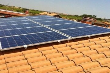 Pannelli solari installati su un tetto di tegole di terracotta sotto un cielo sereno
