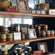 Wall displaying frames, wall art, candles, signs, and decorative items in a store.