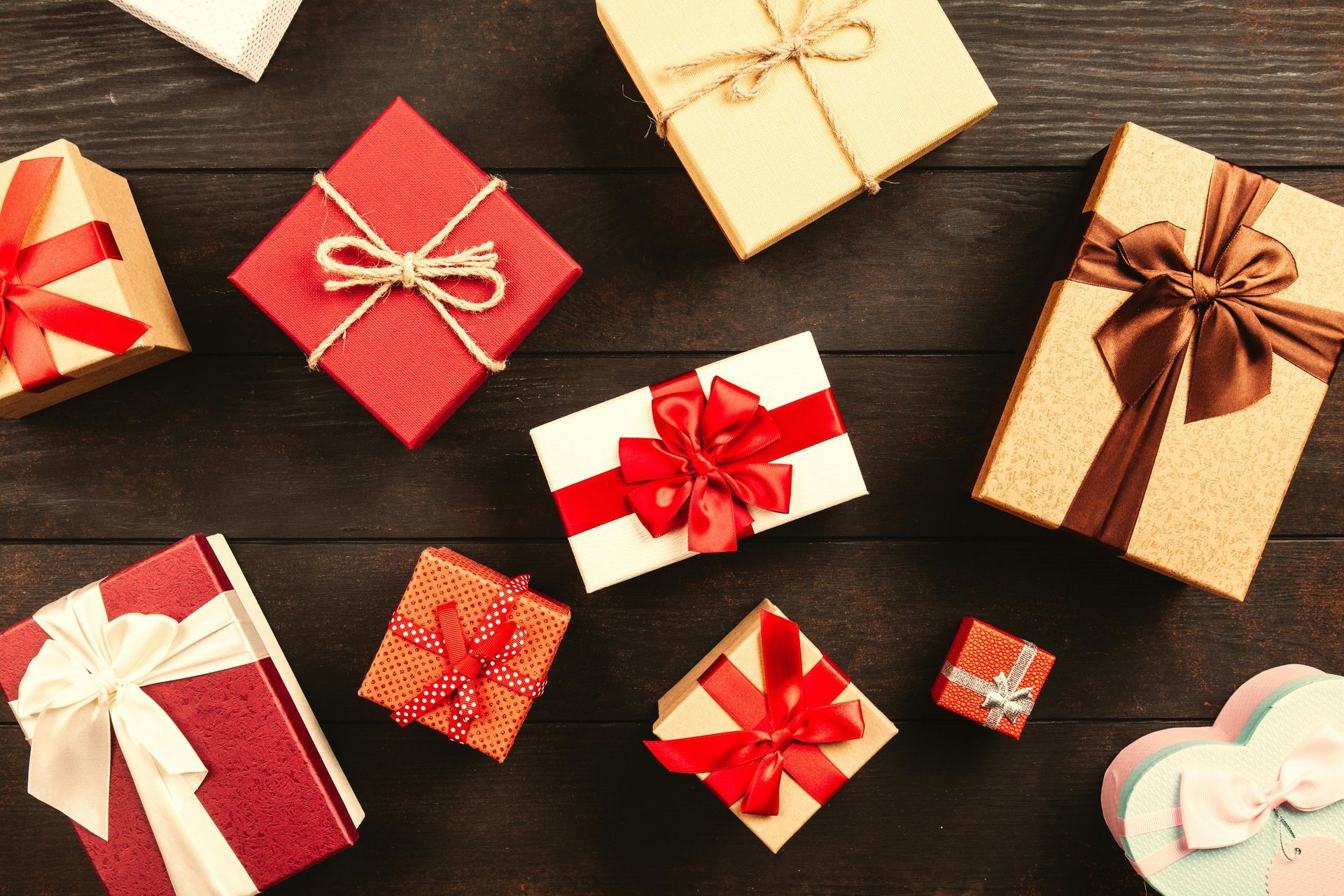 Gift boxes with bows on a dark wood surface.