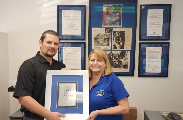 Holding up plaque of AAA Award for Hood's Automotive | Hood's Automotive