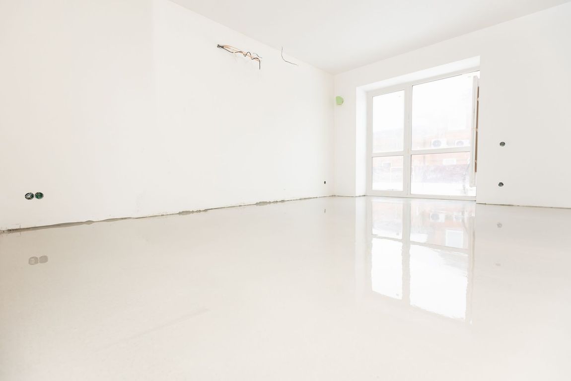 Bright empty white room with glossy floor and glass balcony doors