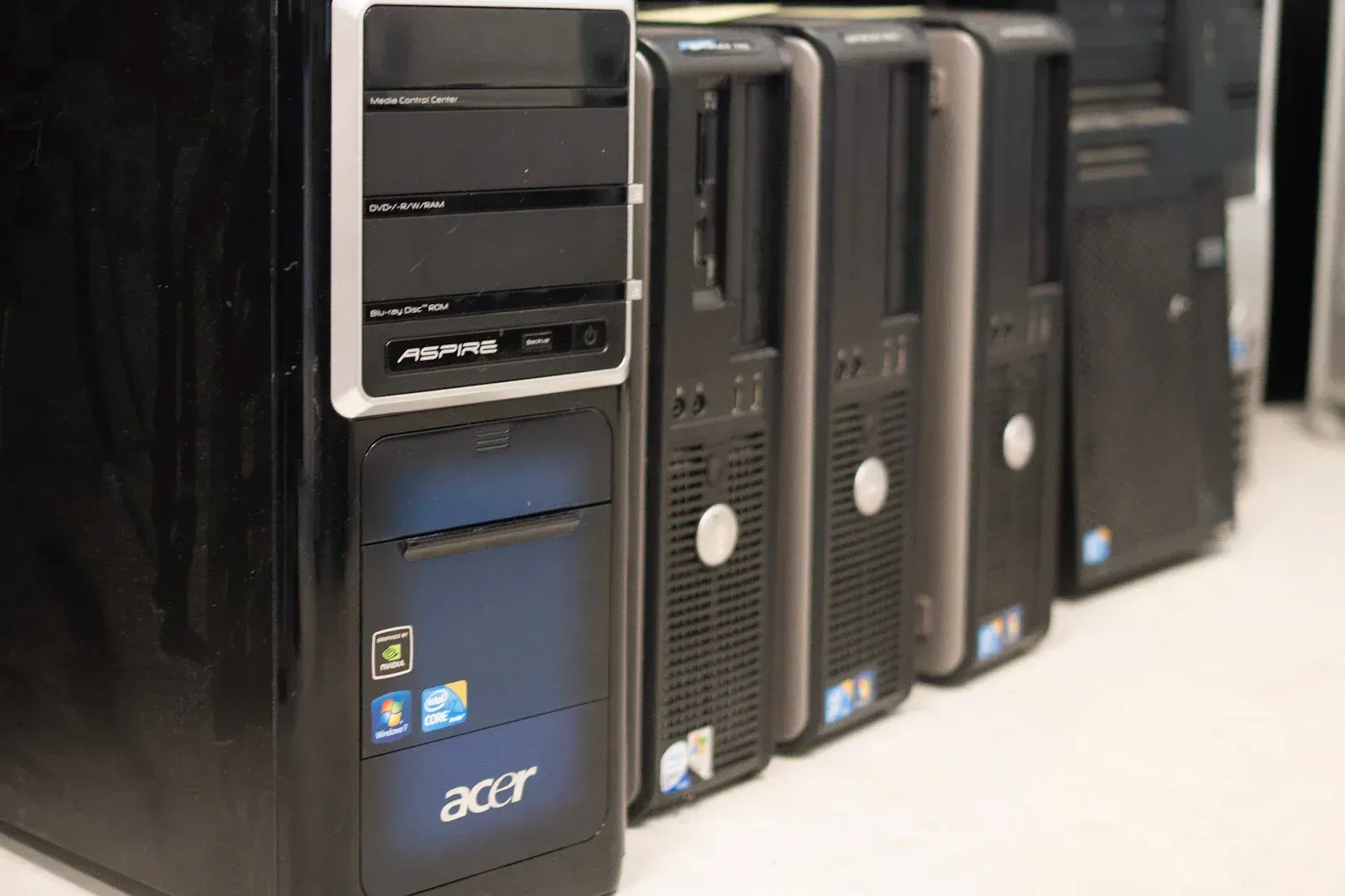 Computadores usados enfileirados sobre uma bancada, prontos para reuso ou reciclagem