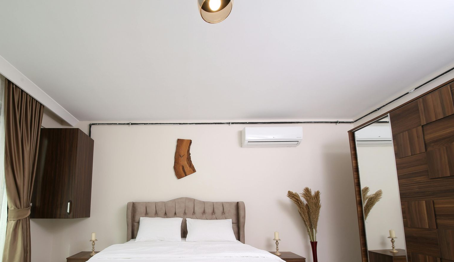 Bedroom with bed, closet, and air conditioner. Neutral tones.