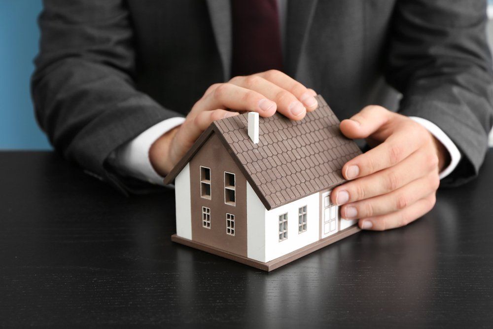 Real Estate Agent With House Model — Loans in Warners Bay, NSW