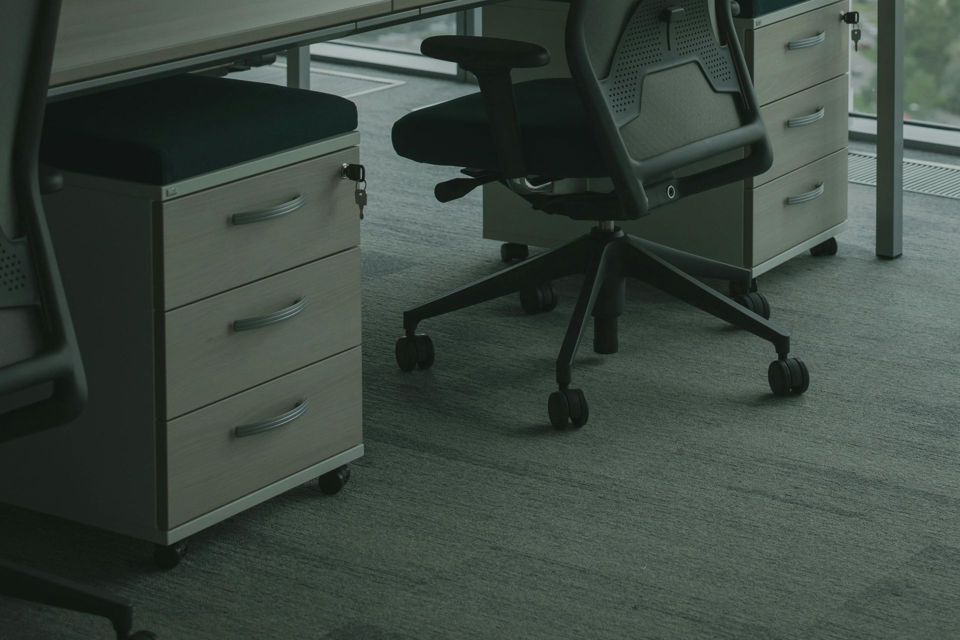 A chair is sitting in front of a desk in an office.