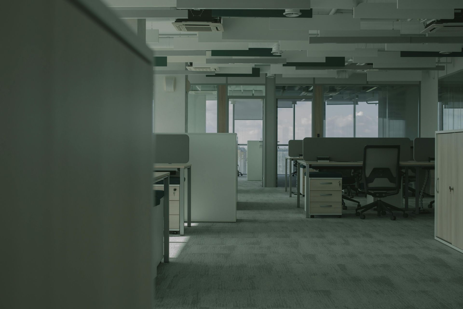 An empty office with a lot of desks and chairs.