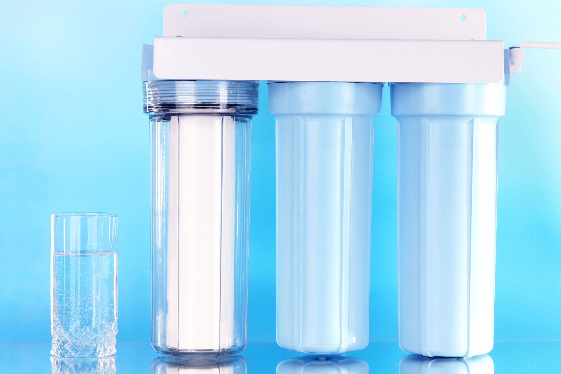 A water filter with a glass of water next to it.