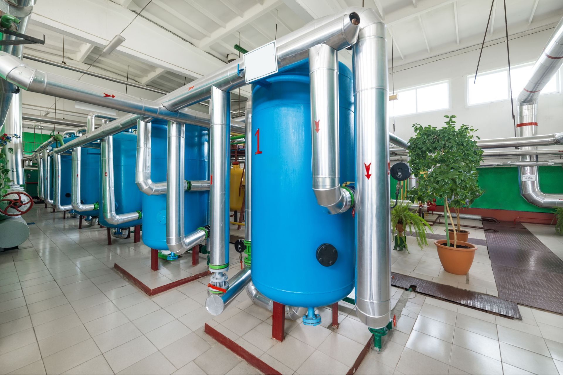 A factory with a lot of blue tanks and pipes.