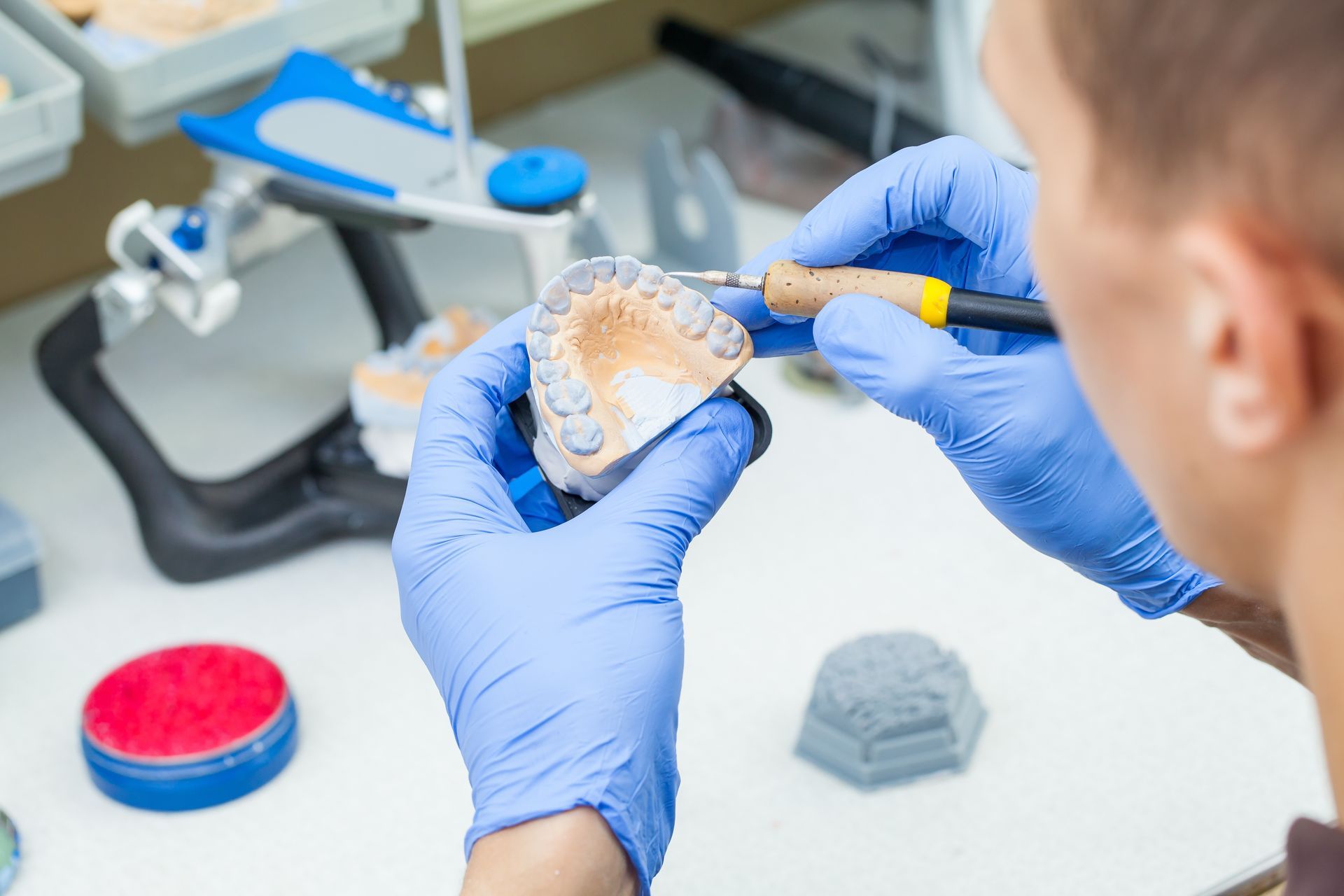 Dental lab technician crafting a custom crown restoration. Dental lab technician crafting a custom crown restoration.