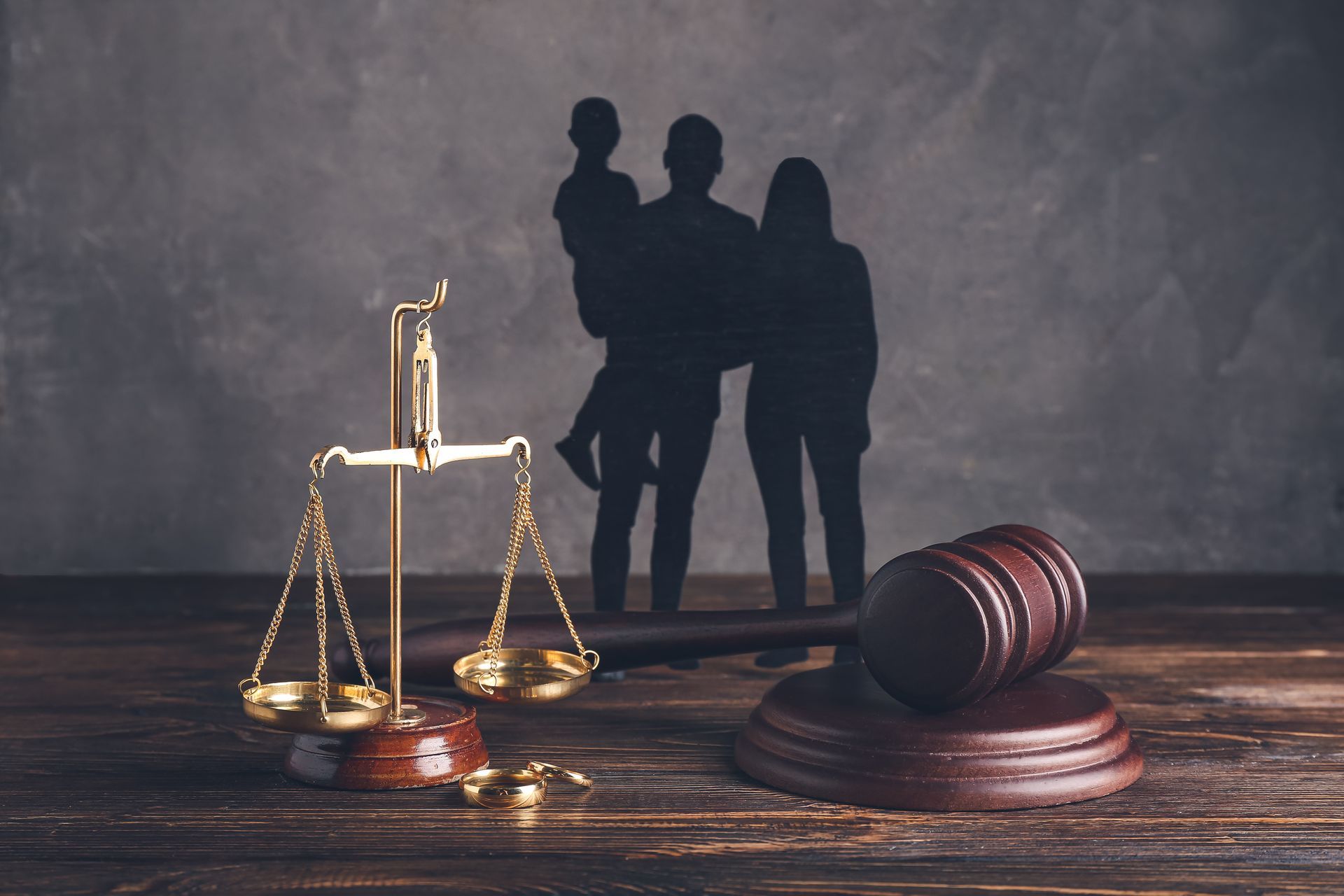 Scales of justice, wedding rings, and gavel symbolizing divorce and family law proceedings