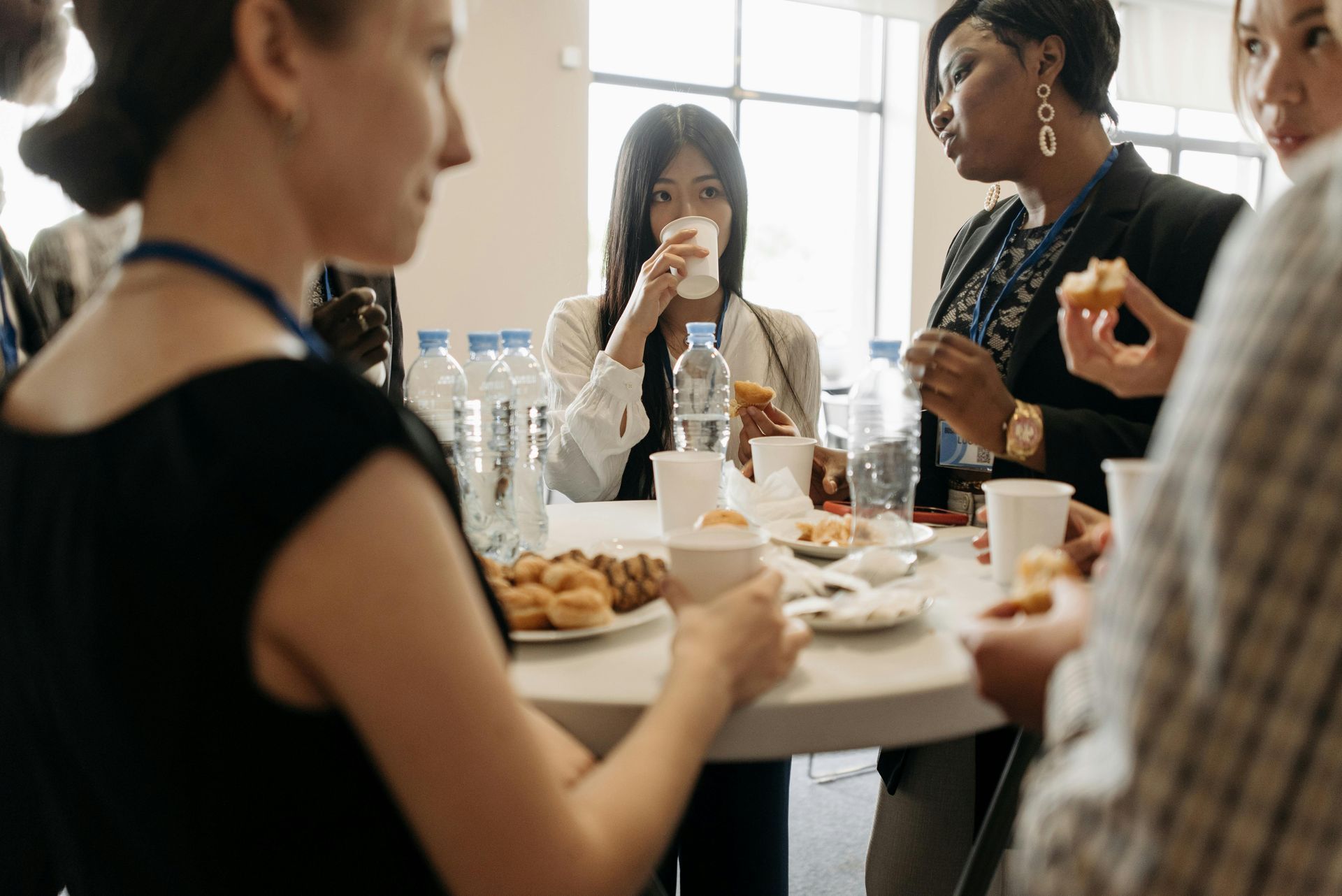 Group event attendees snacking and mingling around the table  