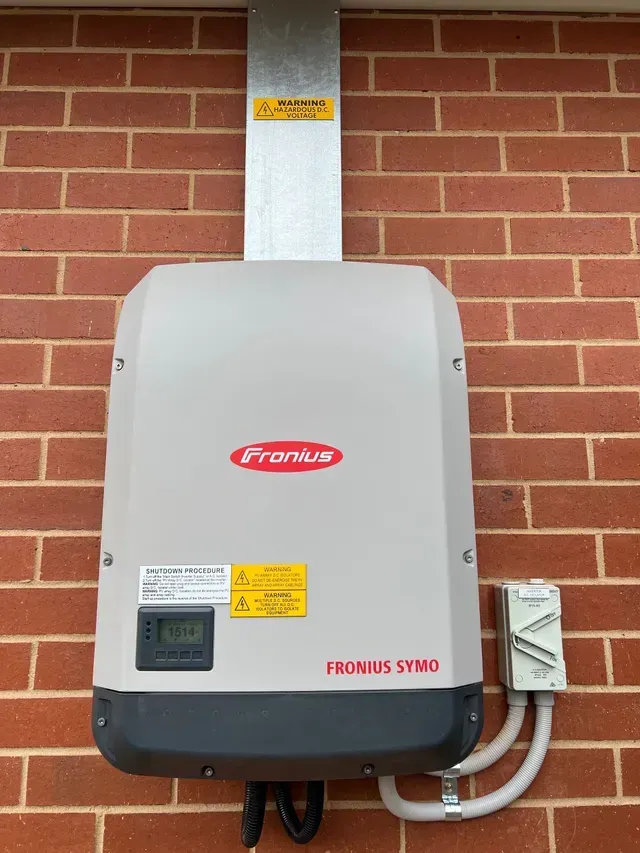 Solar Panel Inverter Mounted on a Brick Wall — Des Mullins Electrical & Solar in Wagga Wagga, NSW