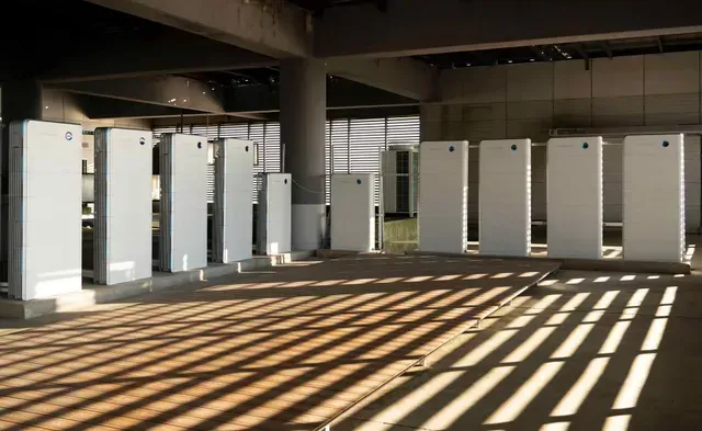 Rows of Tall, White, Rectangular Panels Stand Inside — Des Mullins Electrical & Solar in Wagga Wagga, NSW