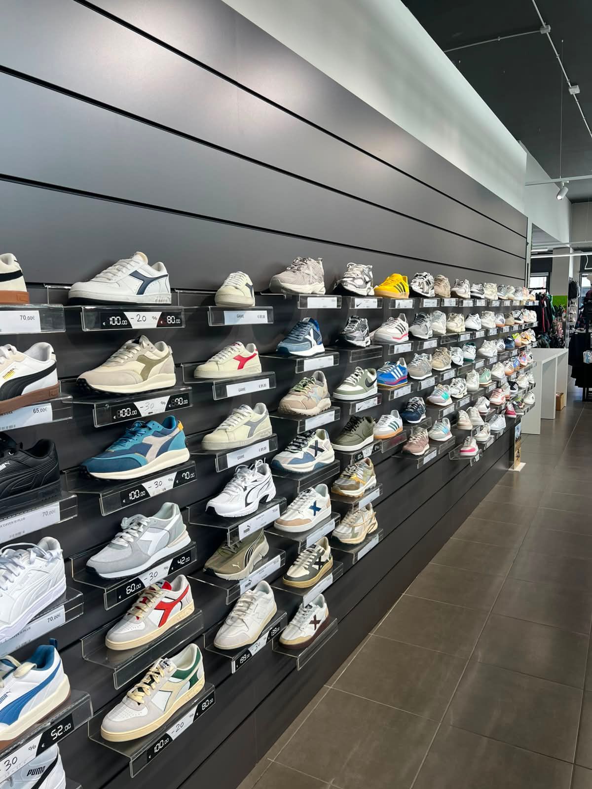 Esposizione interna con modelli di sneakers lifestyle, scarpe sportive per il tempo libero e calzature alla moda quotidiana a Forlì.