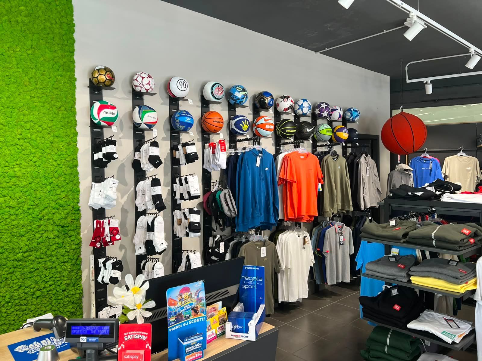 Reparto abbigliamento sportivo tecnico con felpe, t-shirt e completi traspiranti da allenamento esposti nel negozio Sport Service a Forlì.