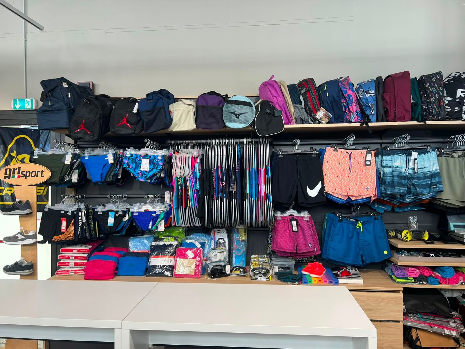 Esposizione di articoli per il nuoto e piscina, con costumi da bagno della linea beachwear, borsoni sportivi e zaini tecnici a Forlì.