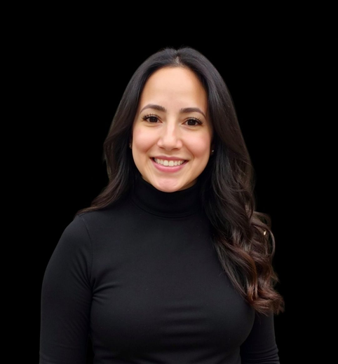 Smiling woman in a black turtleneck against a black background