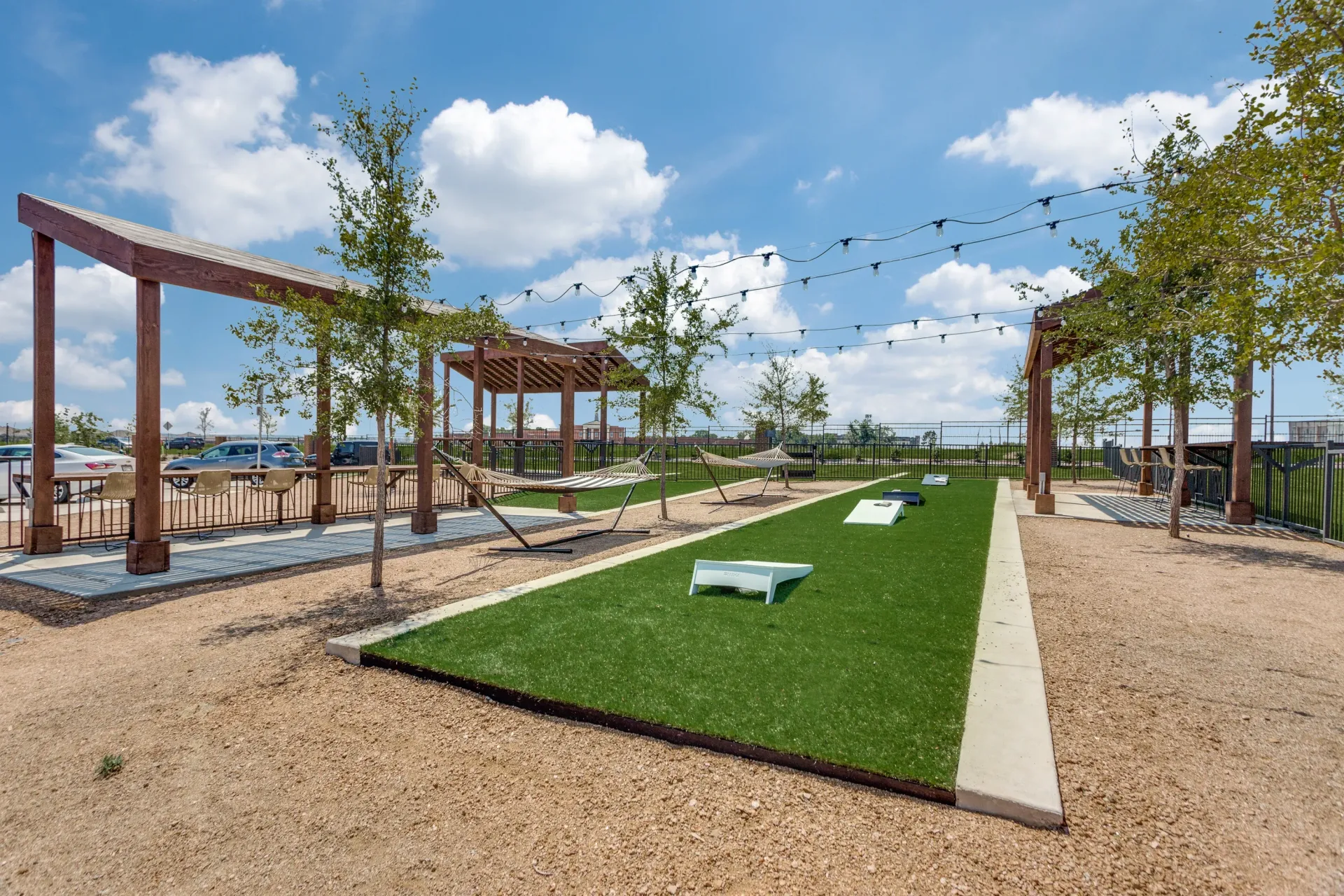 Outdoor recreation area with hammocks and cornhole.