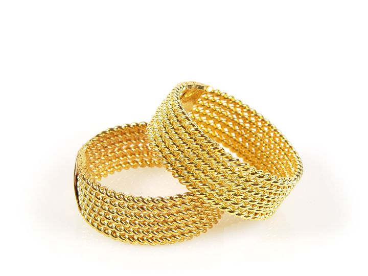 Un paio di braccialetti d'oro su sfondo bianco
