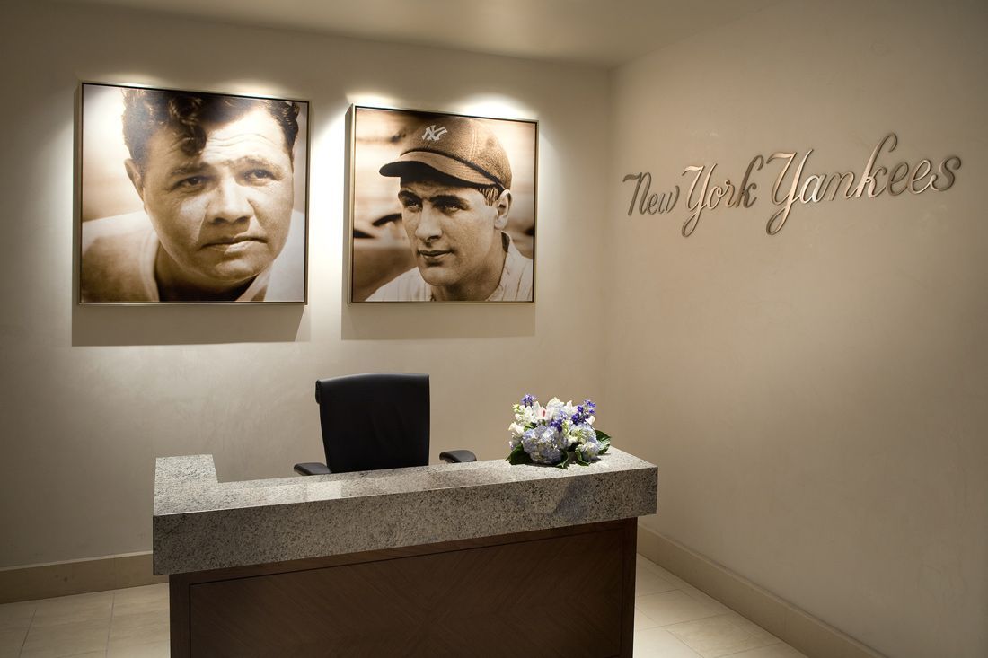 Reception desk with Yankees logo and portraits of baseball players.