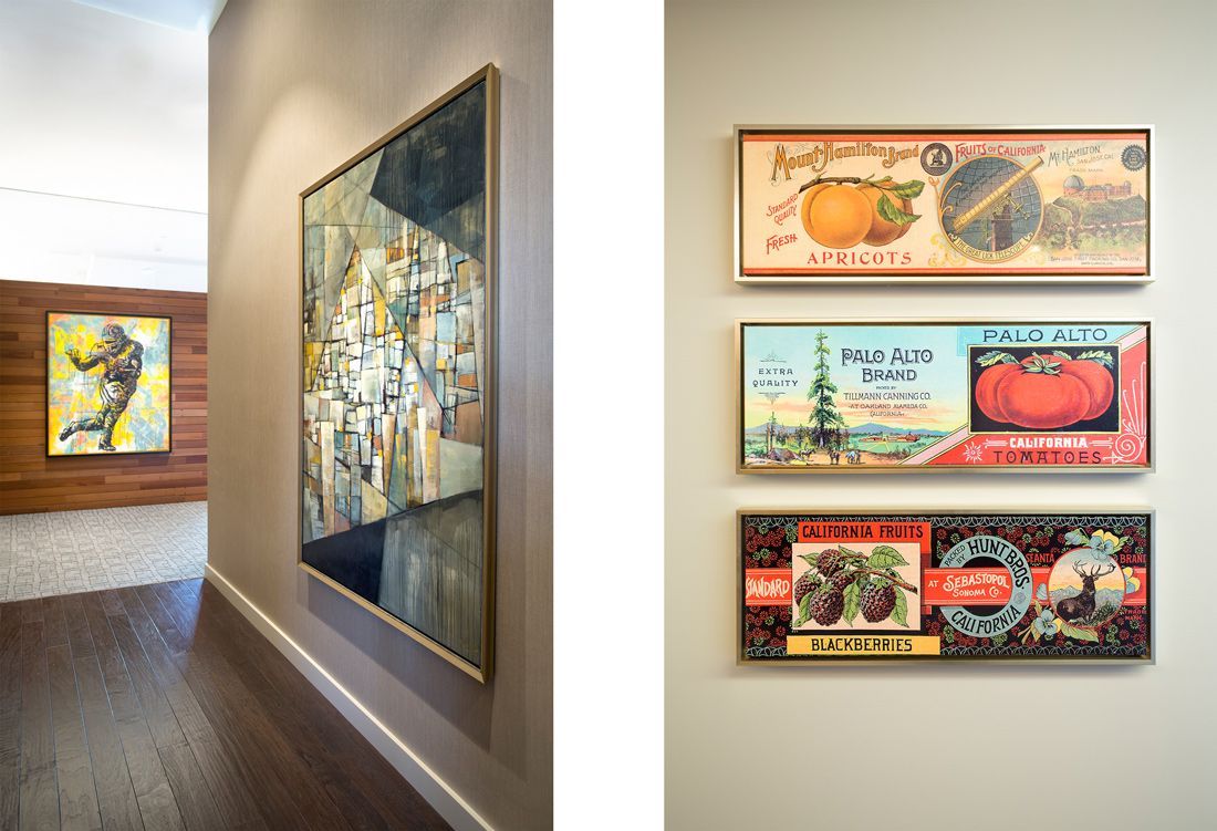 Hallway with artwork. Three rectangular vintage fruit label prints. Another abstract painting on a wall in the background.