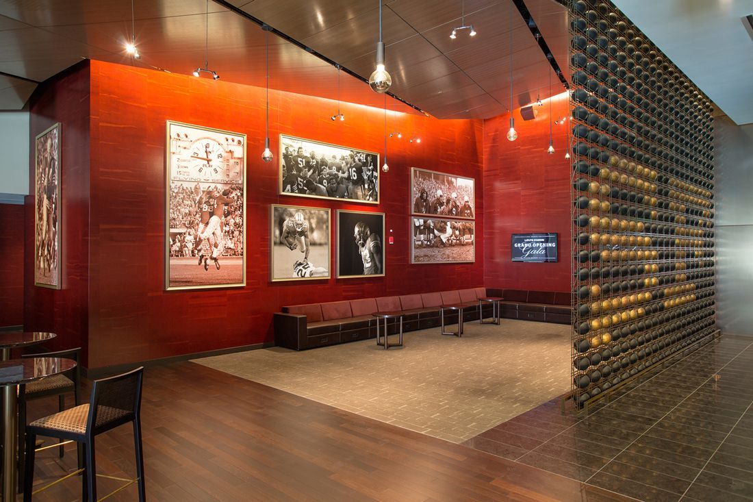 Red-walled room with photos, a seating area, and a wall of circular objects.
