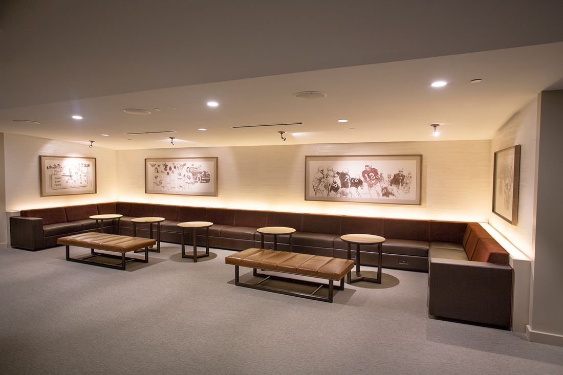 Lounge area with built-in seating, low tables, artwork, and soft lighting.