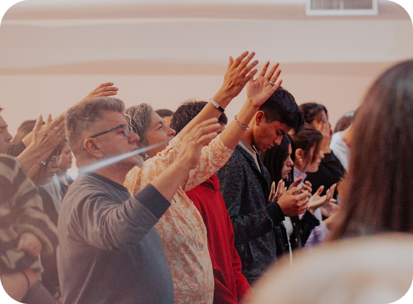 People raising their hands in worship during a church service