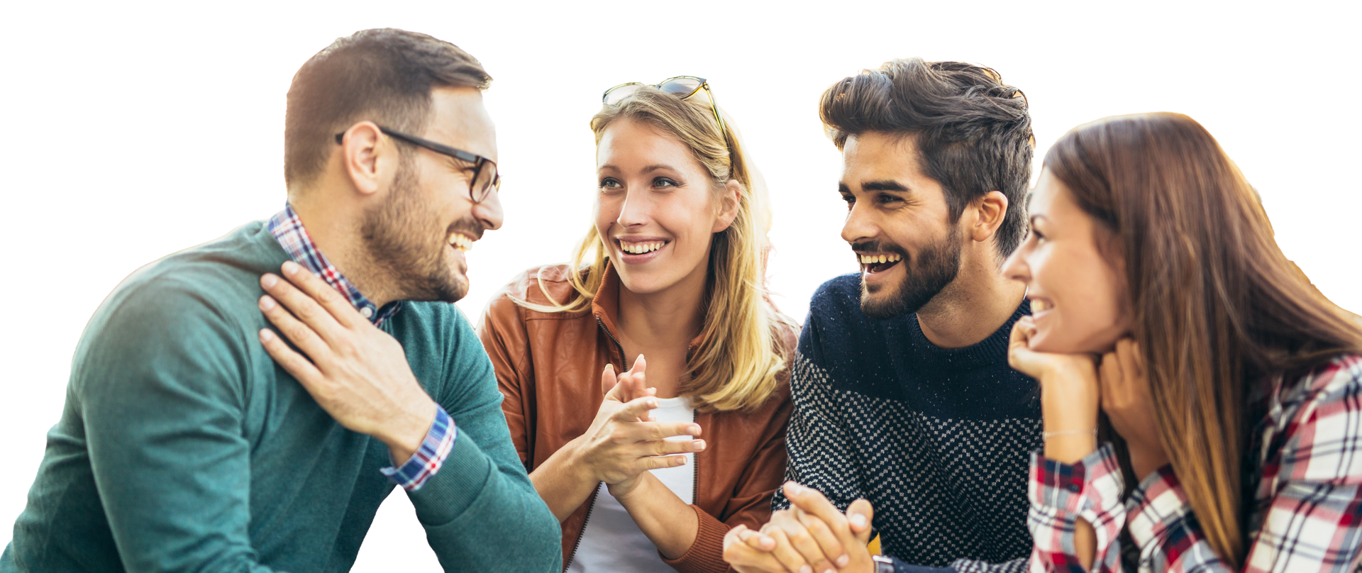 Four friends chatting and smiling together on a couch in a bright room