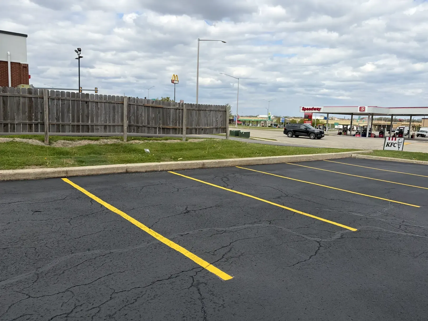 Freshly sealcoated business parking lot with bright yellow markings and clean painted access area.