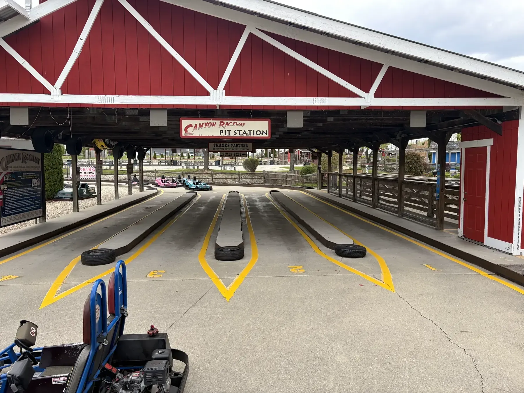 Freshly bright yellow parking stall striping at a family fun park entrance.