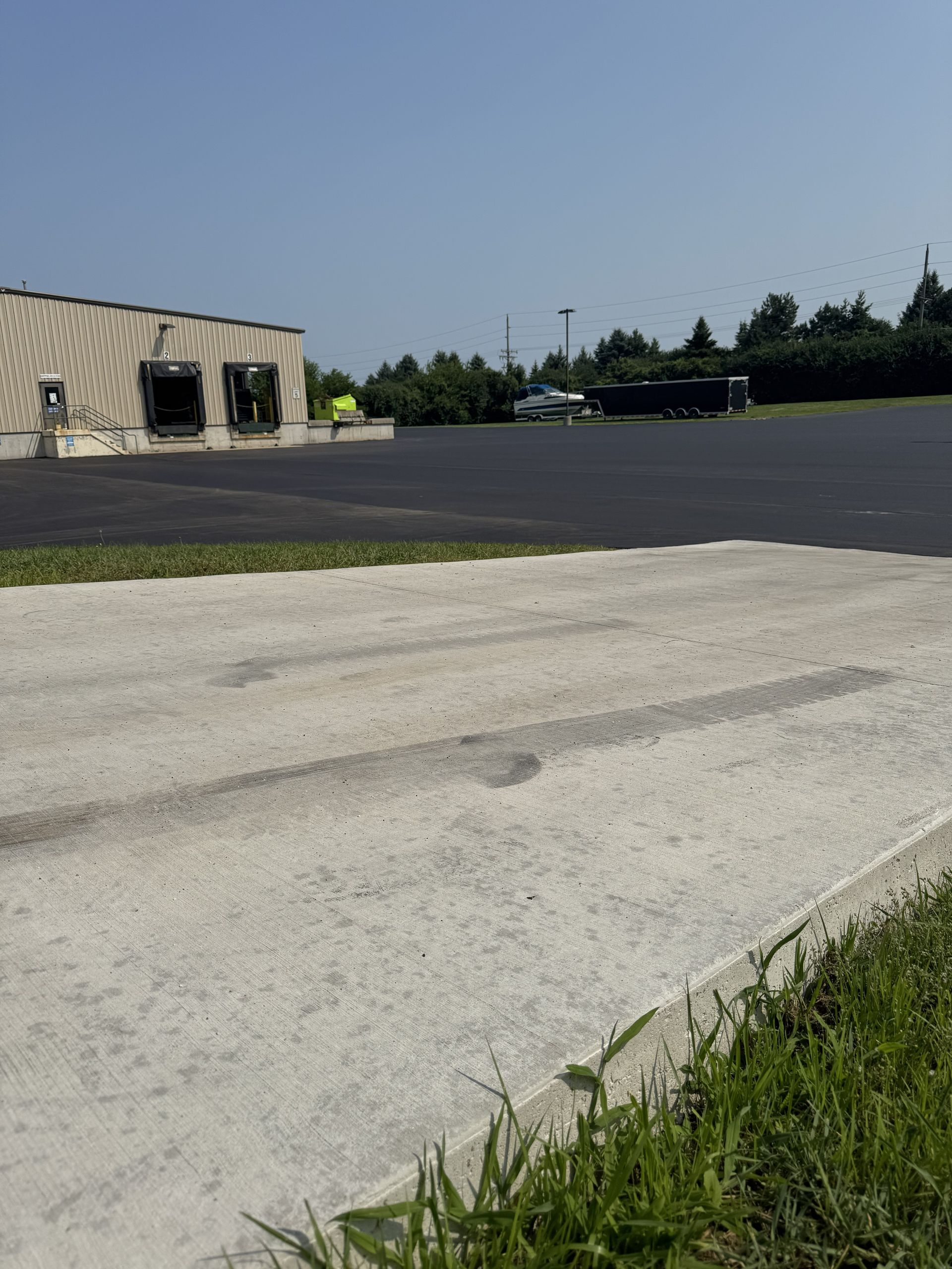 Empty parking lot beside a stone building under a clear blue sky