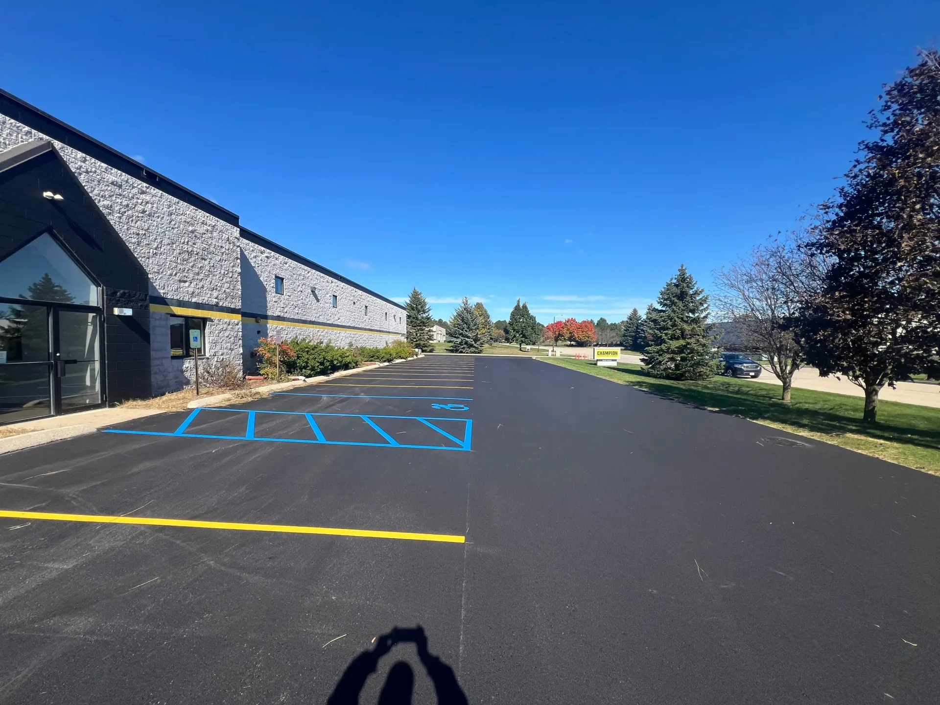 Empty parking lot beside a stone building on a sunny day