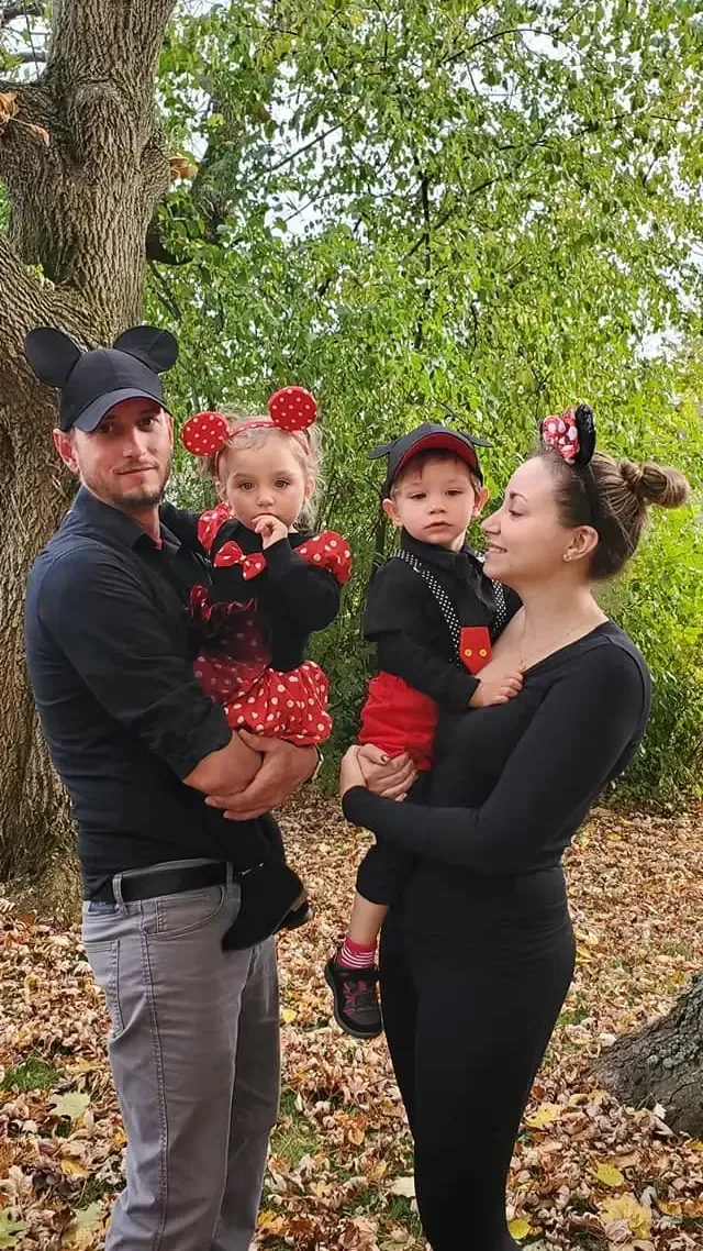 Christopher Morawski, owner of Purpose Contacting Asphalt, with his family wearing matching Mickey and Minnie Mouse costumes outdoors among fall leaves.