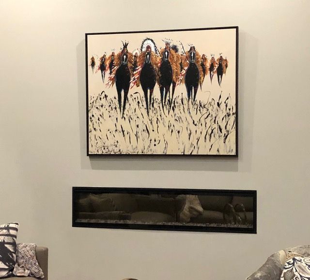 Framed abstract horse painting above a long narrow aquarium on a beige wall