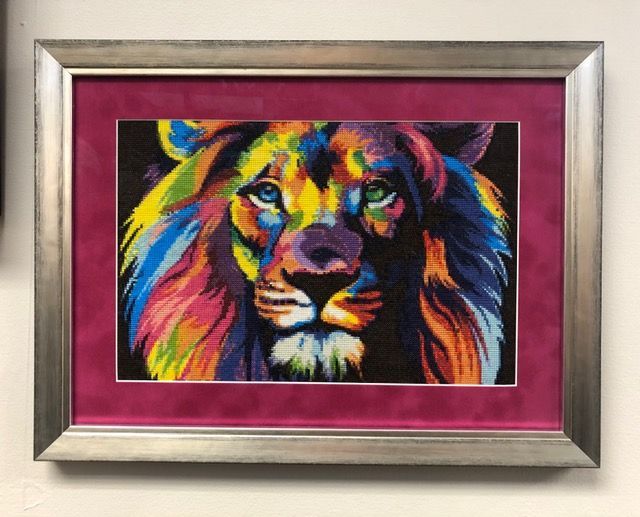 Colorful lion portrait in a silver frame with a magenta mat