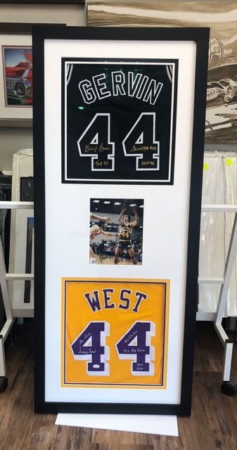 Framed display of two sports jerseys with number 44, one black and one yellow, with a small photo in between