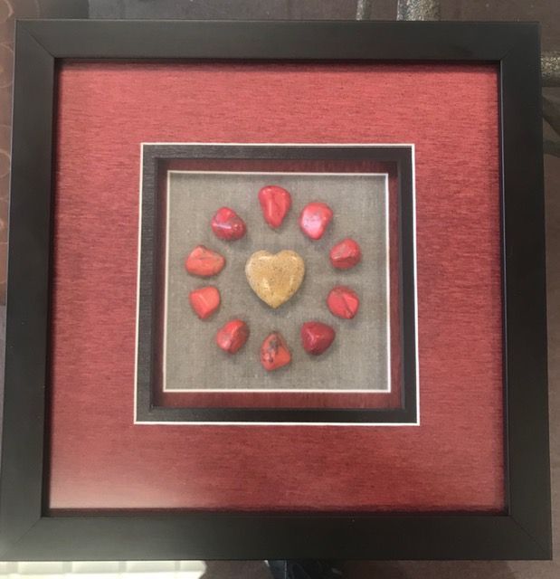 Framed heart-themed wall art with a gold heart center and red heart accents on a red background