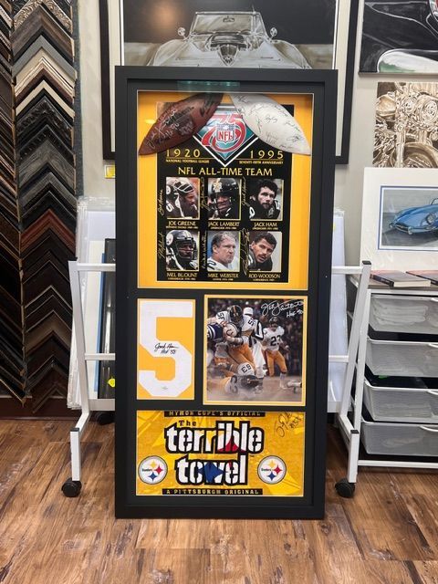 Sports poster display in a black frame on a store stand, with a large yellow “5” and team logos.