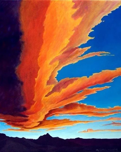 Vivid orange clouds streak across a blue sunset sky above dark mountain silhouettes