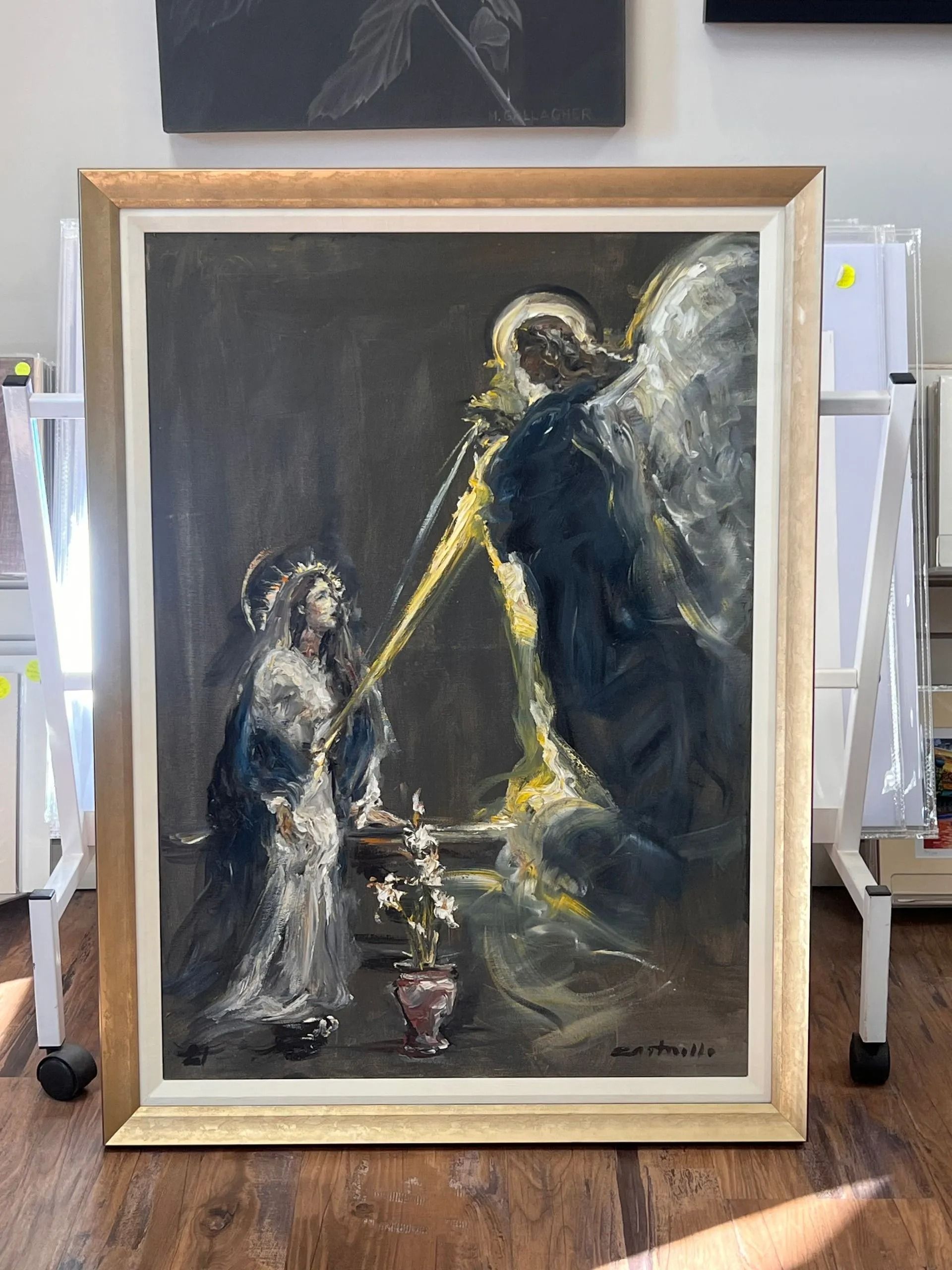 Framed painting of two figures in dark robes, one small and one large, in a dim, moody scene.