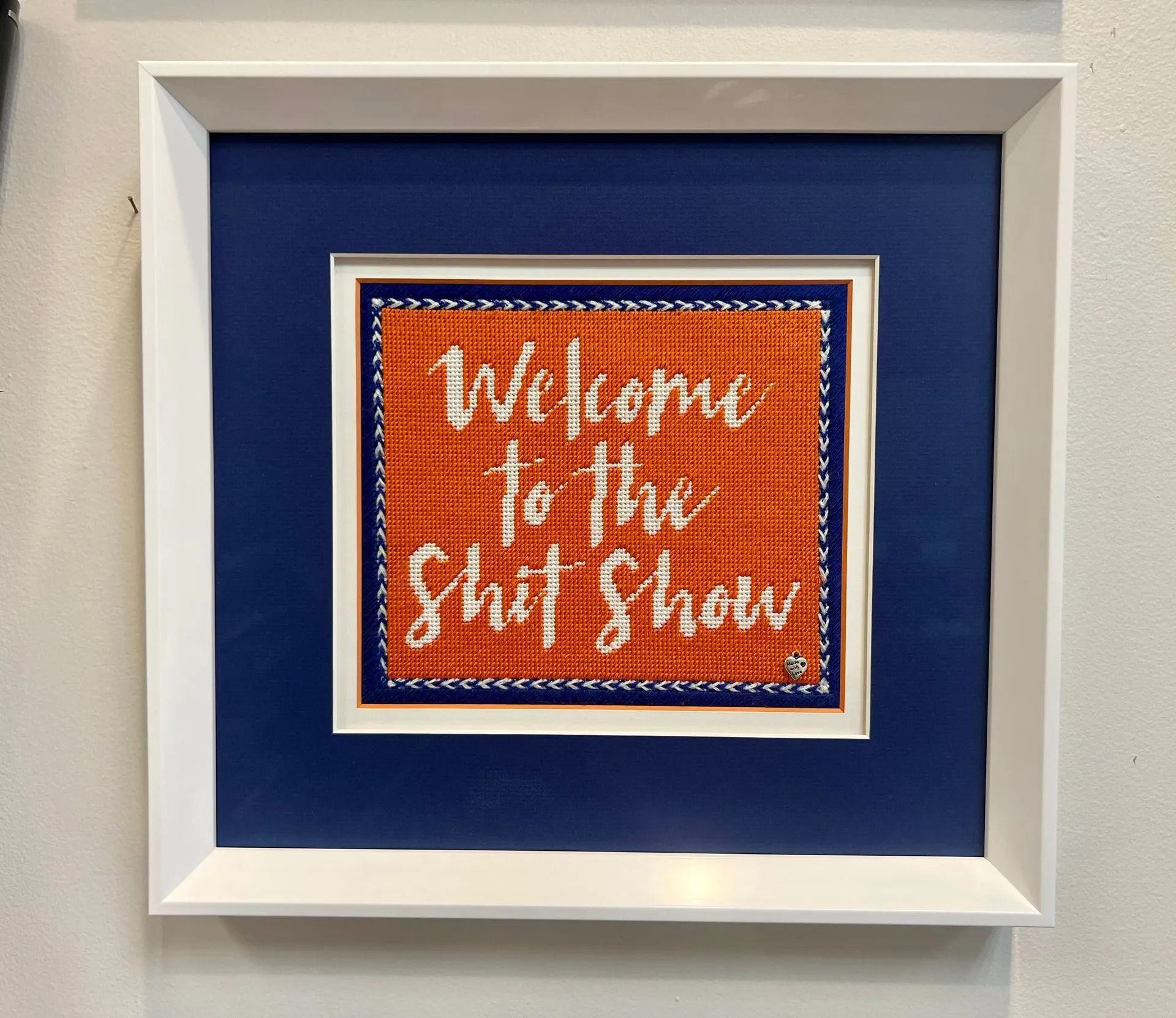 Framed orange sign on blue background reading “Welcome to the … Show”