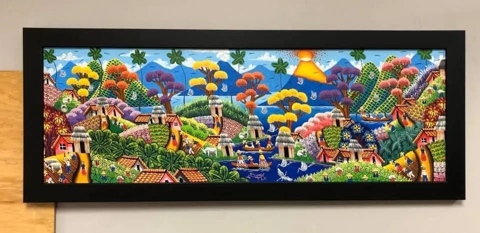 Vibrant abstract cityscape mural with colorful houses, trees, and hills in a black frame