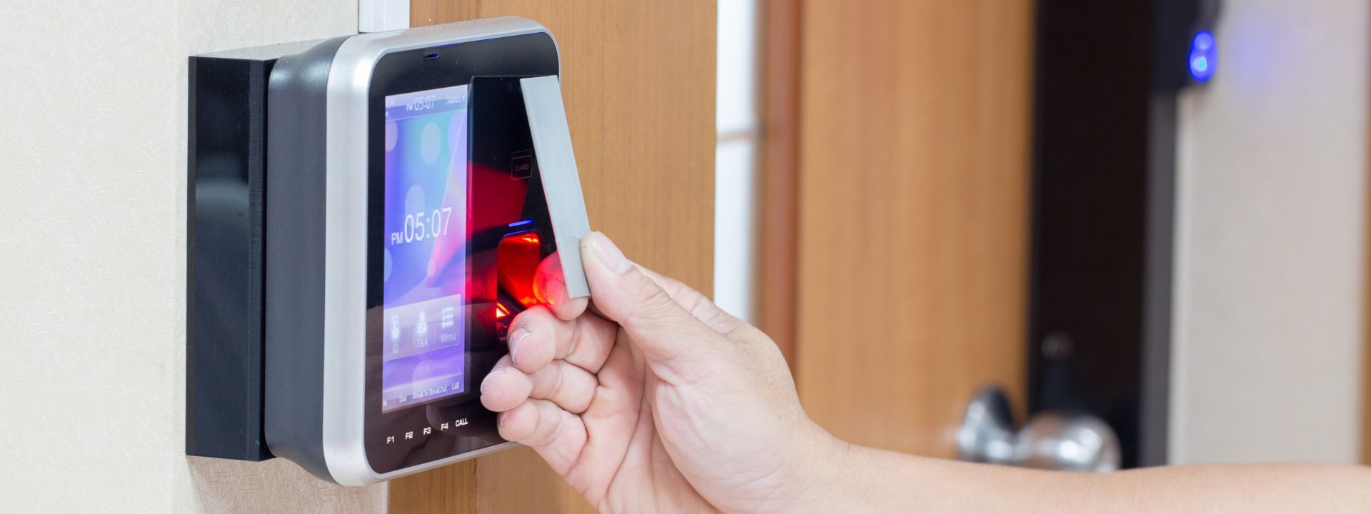 A person is using a fingerprint scanner to open a door.