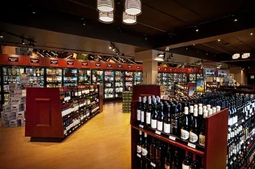 Wine shop interior with shelves of bottles, warm lighting, and a polished wooden floor
