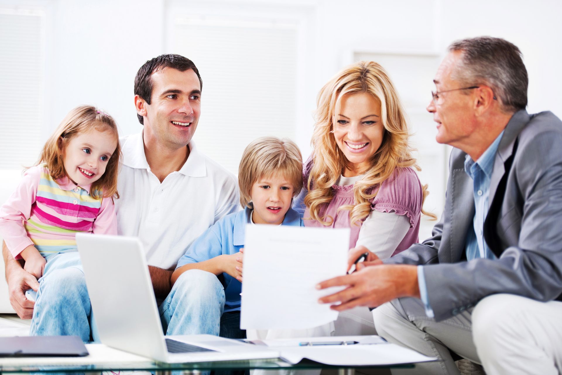 A family gathered around a laptop, reviewing paperwork related to life insurance in Benton Harbor, MI.