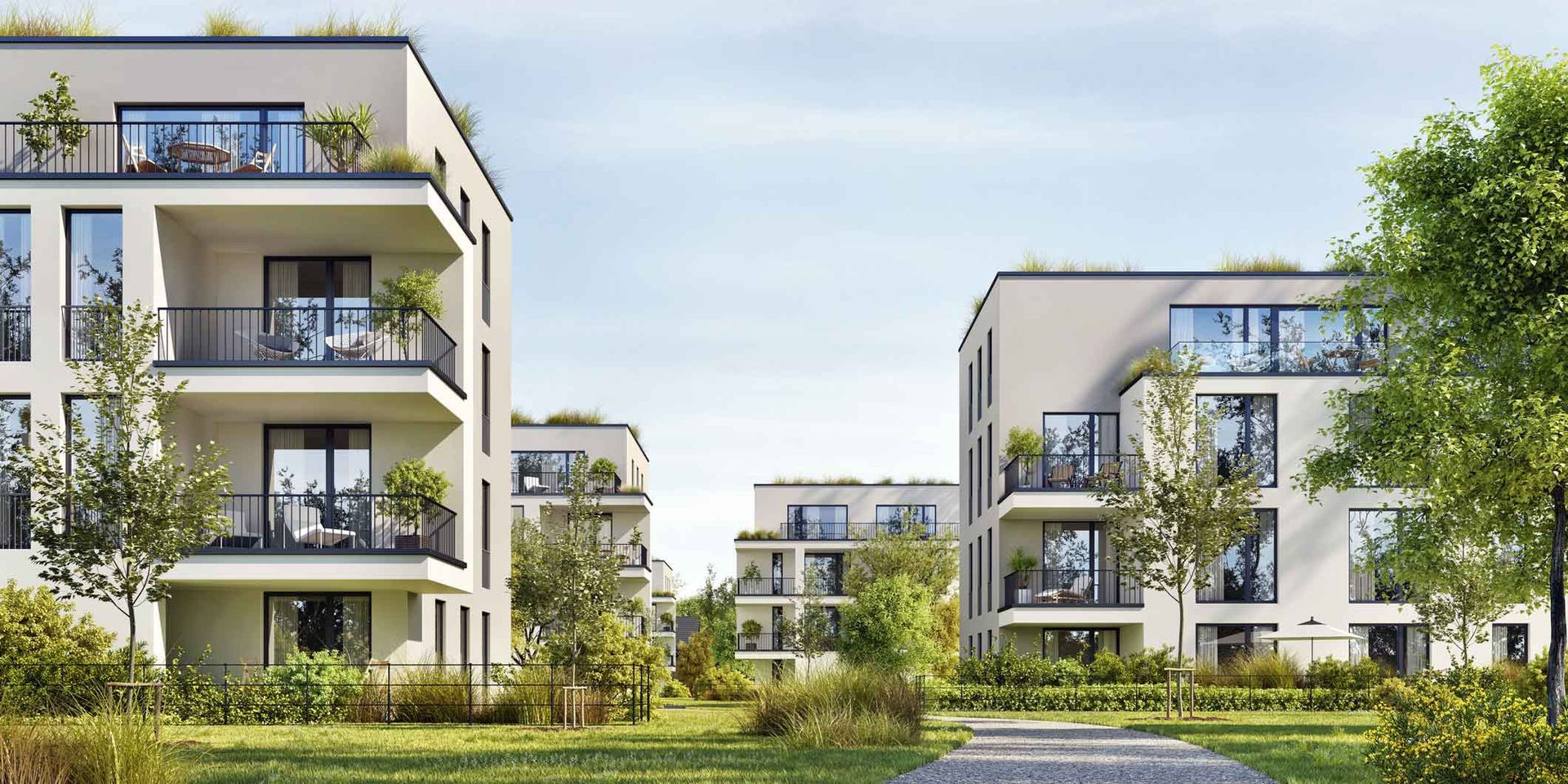 Modern apartment buildings with balconies and greenery in a landscaped residential complex