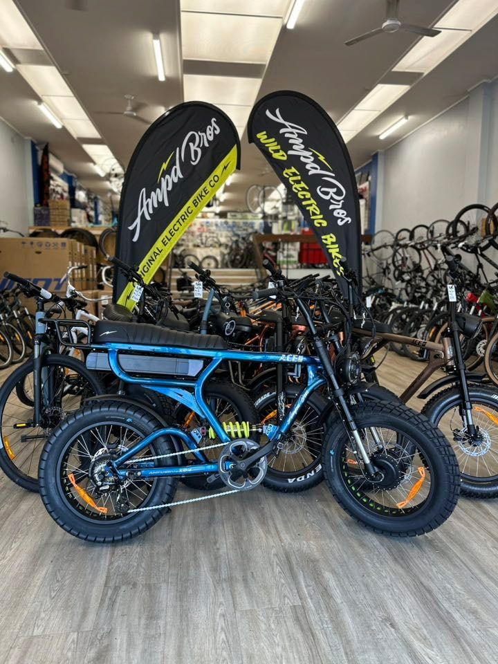 Blue and black electric bike in a bike shop, flanked by promotional banners — Grafton City Cycles in Grafton, NSW